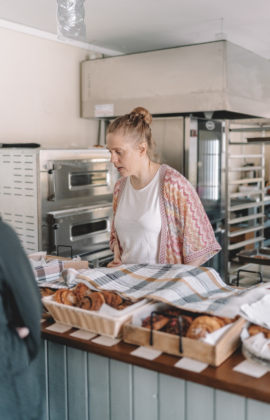 A baker in a kitchen, mid-task, photographed in warm natural light. Stand-in image — replace with the real team portrait before launch.